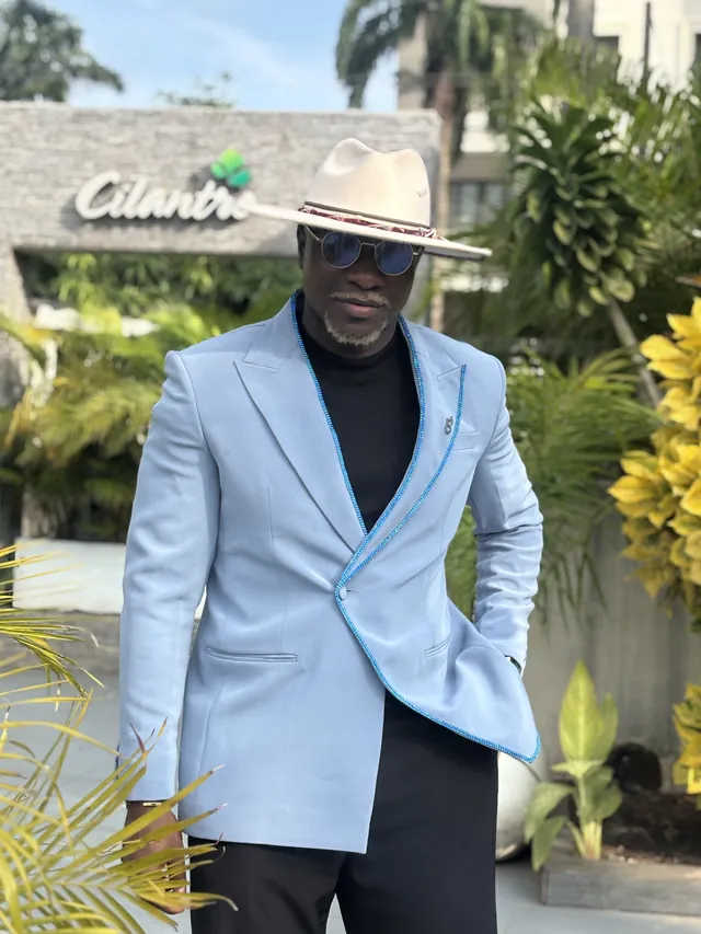 Theo hosting outdoors in a powder blue blazer